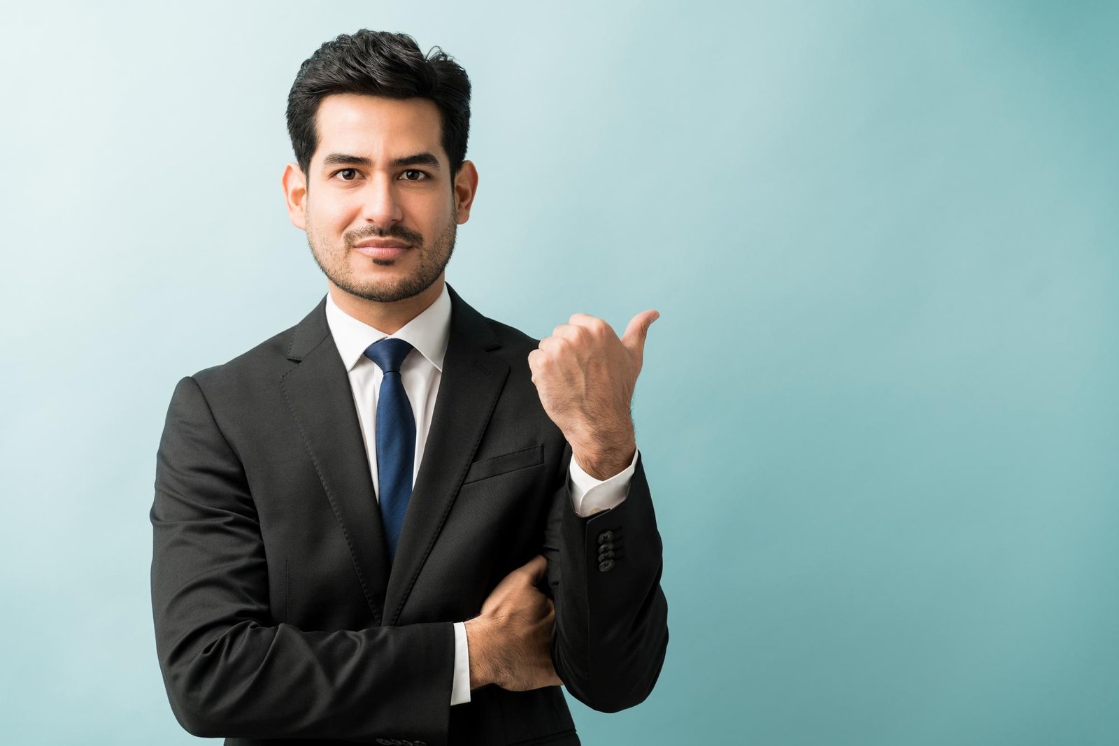 hispanic-male-executive-gesturing-copy-space-while-making-eye-contact-studio